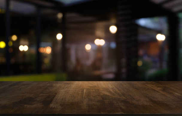 Üres sötét fa asztal előtt elvont elmosódott bokeh háttér étterem. lehet használni megjelenítésére vagy montázs a termékeket.Mock up for space - Fotó, kép