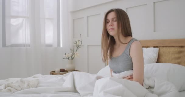 Young woman suffering from stomachache. Her menstrual cramps are too painful to go to work. woman suffering from stomach ache. suffering from severe pain and cramp in lower abdomen, - Footage, Video