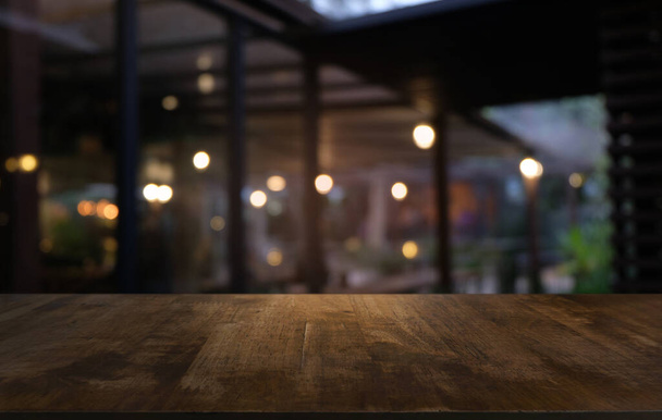 Üres sötét fa asztal előtt elvont elmosódott bokeh háttér étterem. lehet használni megjelenítésére vagy montázs a termékeket.Mock up for space - Fotó, kép