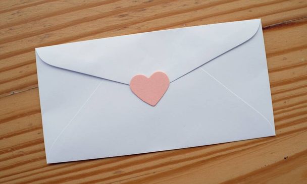 Valentijnsdag liefdesbrief envelop met hartjes op houten achtergrond. kopieerruimte - Foto, afbeelding