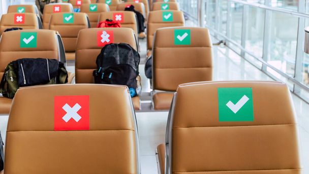Odległość społeczna, Rzędy pustych krzeseł w strefie odlotu lotniska oznaczone symbolami dotyczącymi protokołu dystansowania społecznego w celu zapobieżenia rozprzestrzenianiu się nowego wirusa korony, COVID-19 w Tajlandii - Zdjęcie, obraz