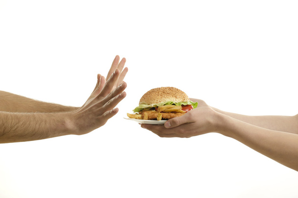 Hands offering a big hamburger and hungry hands ready to deny,isolated on white - Foto, Imagem