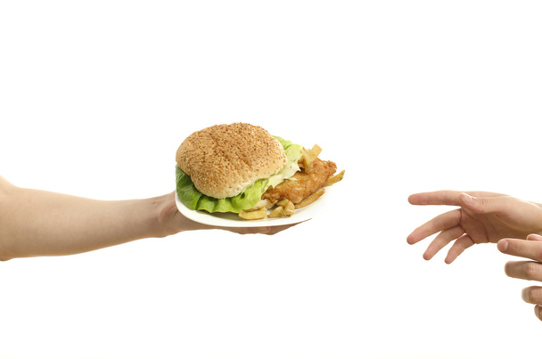 Mãos oferecendo um grande hambúrguer e mãos famintas pronto para receber, isolado em branco
 - Foto, Imagem