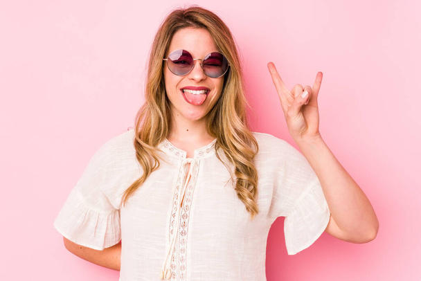 Young caucian woman with glasses isolated on pink background showing rock gesture with fingers - Фото, зображення