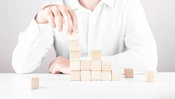 businessman climbs the career ladder. Business concept from cubes. - Foto, Imagen