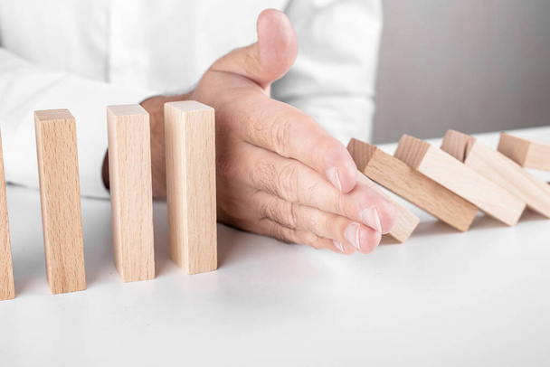 Een mannelijke zakenman, Jenga, houten blokken. een concept over carrièregroei, verzekeringen - Foto, afbeelding