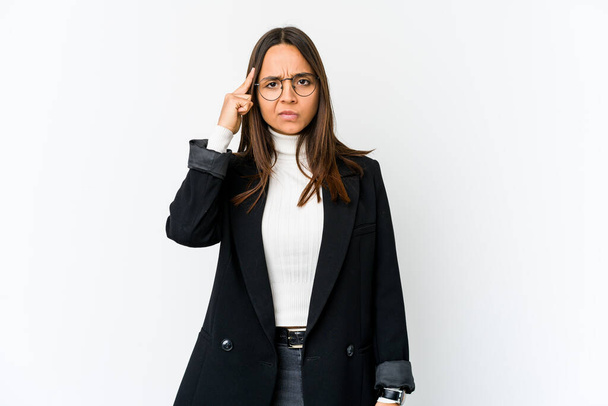 Junge Geschäftsfrau mit gemischter Rasse isoliert auf weißem Hintergrund zeigt mit dem Finger auf die Schläfe, denkt nach, konzentriert sich auf eine Aufgabe. - Foto, Bild