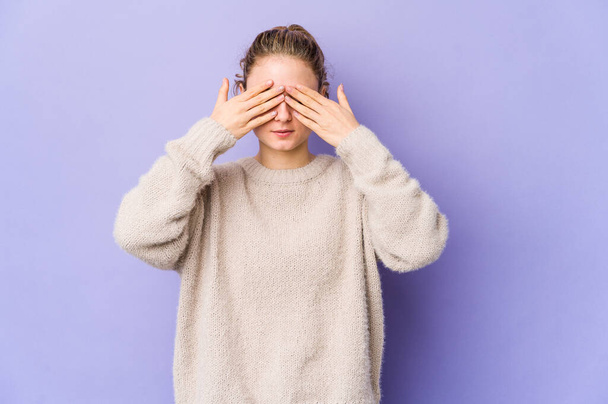Young caucasian woman on purple background afraid covering eyes with hands. - Foto, Imagem