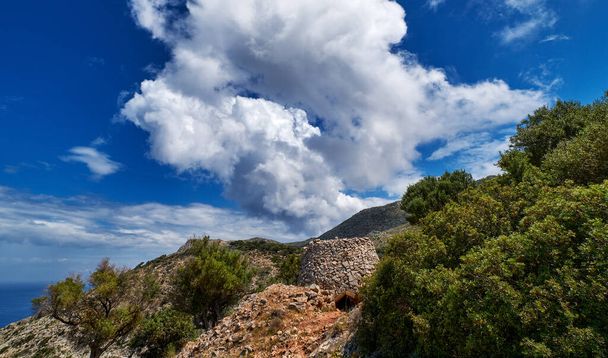 Typical Greek landscape, hill, mountain, spring foliage, bush, olive tree, rocky path. Blue sky with beautiful clouds. Akrotiri, Chania, Crete, Greece - Fotó, kép