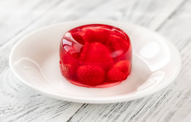 Porción de postre de gelatina de frambuesa en plato blanco - Foto, imagen