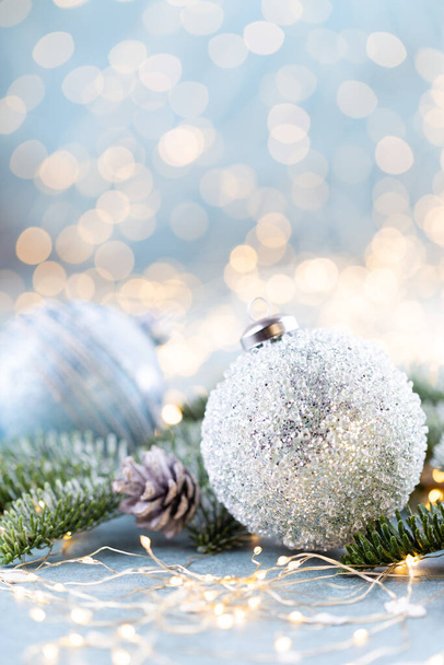 Christmas spruce with ball and blurred shiny lights. - 写真・画像