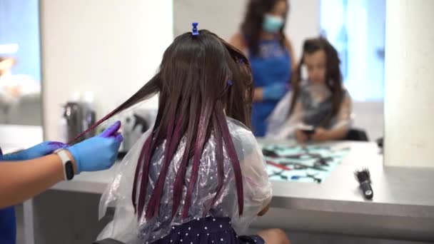 coiffeur teint cheveux petite fille rose dans le salon de coiffure - Séquence, vidéo