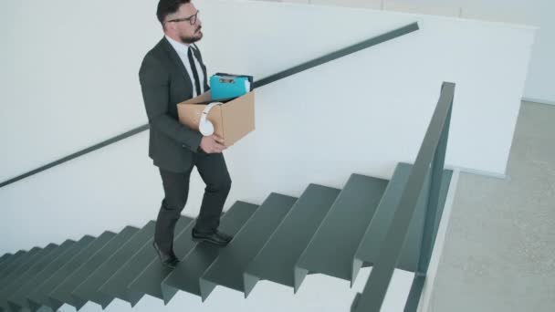 Séquence de clichés de l'homme élégant apportant boîte avec des objets personnels et des documents dans la salle de bureau après la quarantaine covid-19 - Séquence, vidéo