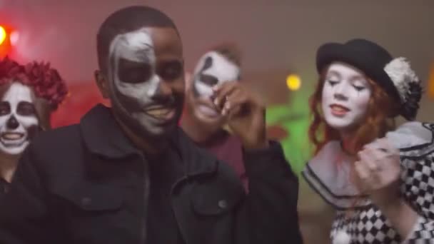 Portrait of happy young people wearing halloween costumes dancing to music at house party - Footage, Video