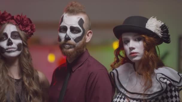Retrato panorámico de amigos que usan maquillaje y disfraces de Halloween posando para la cámara juntos en la fiesta de la casa - Metraje, vídeo