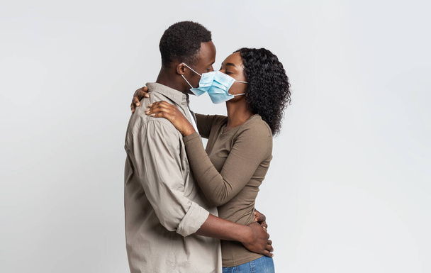 Black Couple Kissing Each Other In Protective Medical Masks - Foto, Imagen