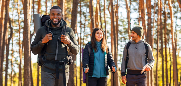 Glückliche multiethnische Freunde wandern gemeinsam durch die Landschaft - Foto, Bild
