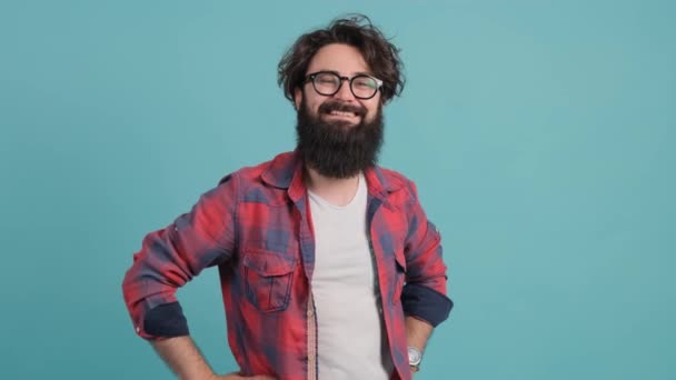 Close up of smiling bearded man pointing at you over turquoise background. - Footage, Video