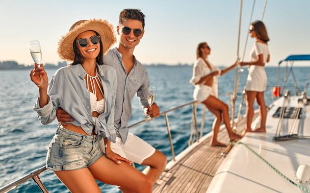Group of friends relaxing on luxury yacht. Having fun together while sailing in the sea. Traveling and yachting concept. - Foto, Imagen