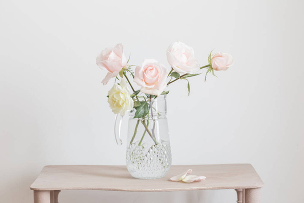beautiful roses in glass jug on white background - Foto, afbeelding