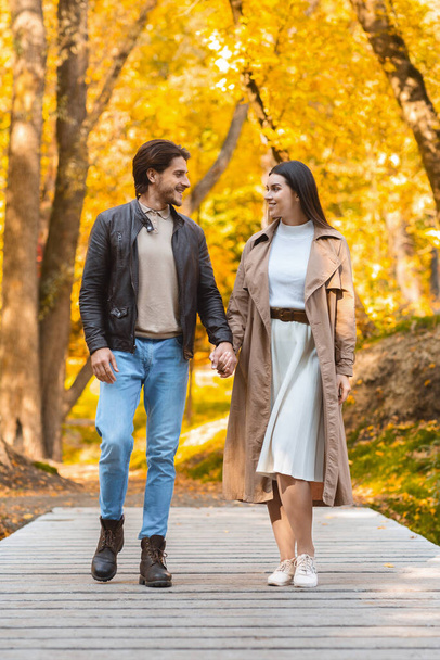 Jovem homem e mulher tendo encontro romântico na floresta dourada - Foto, Imagem