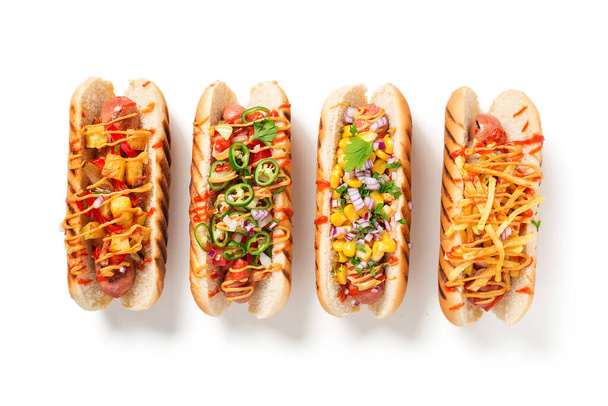 Hot Dogs voll beladen mit verschiedenen Belägen. isoliert auf weißem Hintergrund - Foto, Bild