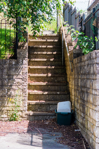 Passos de concreto exterior com uma tigela de plástico e garrafa na parte inferior levando a um caminho para acessar jardins povos - Foto, Imagem