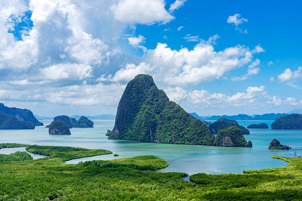 タイの緑豊かなマングローブ林、白い雲と青い空を持つパンガー湾の石灰岩の島. - 写真・画像