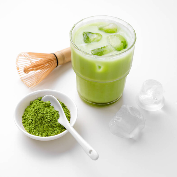 Matcha zielona herbata lód latte z matcha proszku i bambusowy trzepaczka. - Zdjęcie, obraz