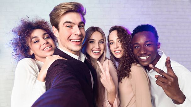 Millennial mensen maken selfie plezier op corporate party binnen - Foto, afbeelding