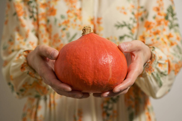 Donna in vestire tenere in mano autunno zucca - Foto, immagini
