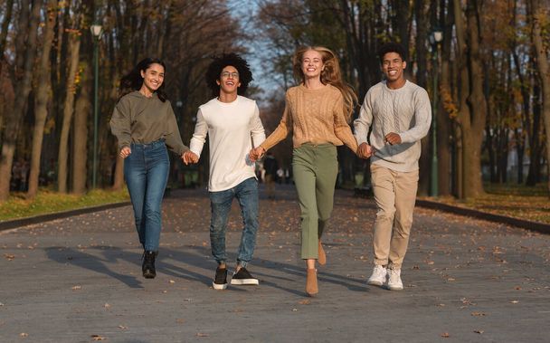 Verrückte Teenager-Freunde rennen auf Kamera zu, Park-Hintergrund - Foto, Bild