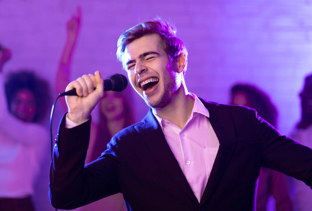 Utalentowany facet śpiewa piosenkę o imprezie karaoke w nocnym klubie - Zdjęcie, obraz