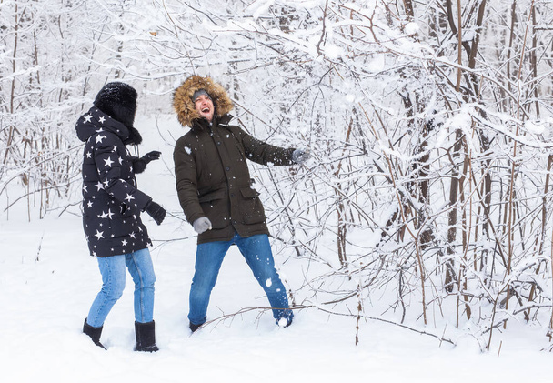 Genç aşık çift karlı ormanda eğleniyor. Aktif kış tatili. - Fotoğraf, Görsel