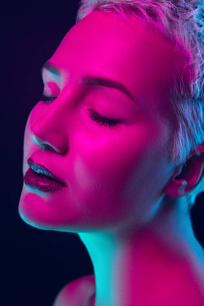 Portrait of female fashion model in neon light on dark studio background. - Fotoğraf, Görsel