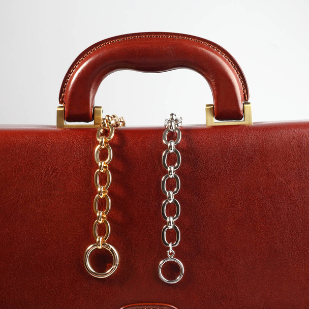 Two chain necklaces on male brown leather case. Close-up shot - Foto, Bild