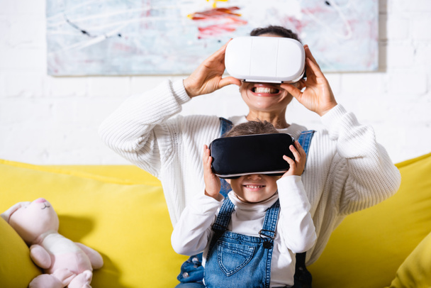 Selective focus of mother and daughter using virtual reality headsets at home - Fotoğraf, Görsel