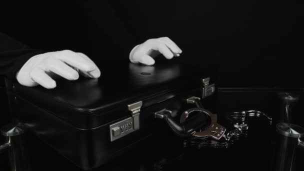 Handen en zwarte koffer met handboeien - Video