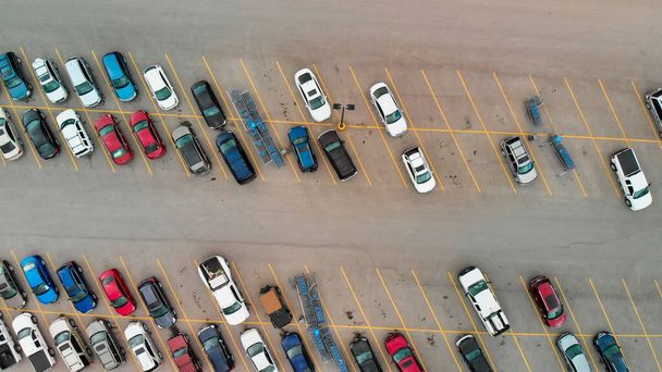 Aerial view of cars at large outdoor parking lots; USA. Outlet mall parking congestion and crowded parking lot; other cars try getting in and out; finding parking space. Panorama; downward drone viewpoint - Photo, Image