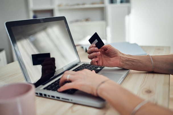 Vrouw met kredietkaart en online kopen met een moderne laptop. - Foto, afbeelding