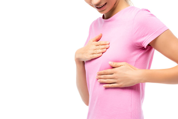 Cropped view of woman in pink t-shirt touching breast isolated on white - Valokuva, kuva