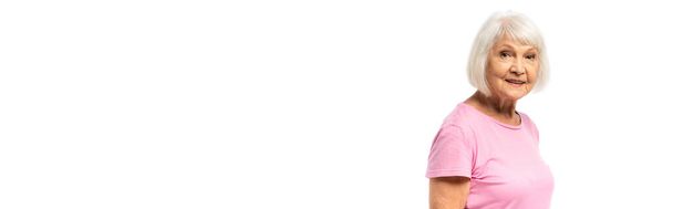 Панорамна орієнтація літньої жінки в рожевій футболці дивиться на камеру ізольовано на білому
 - Фото, зображення
