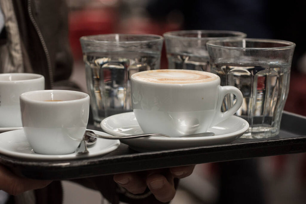 een kop koffie bestellen en drinken in een koffiehuis - Foto, afbeelding
