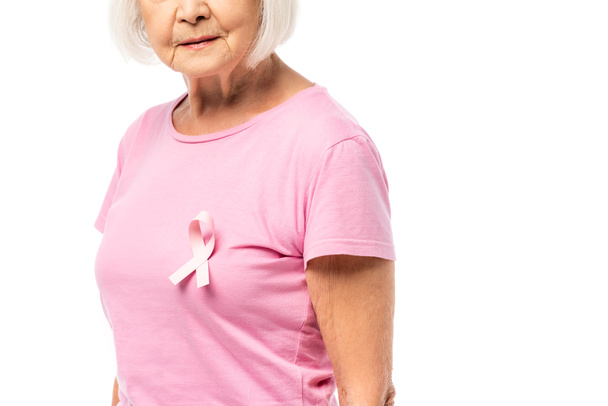 Обрезанный вид пожилой женщины с розовой лентой рака молочной железы осведомленности на футболке изолированы на белом - Фото, изображение