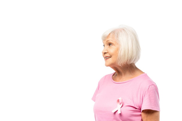 白髪の女性とともに乳がんの意識のリボンでTシャツ見ます離れて白い上に隔離 - 写真・画像