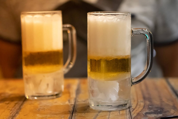 Кувшины пива помещены на деревянный бар. Закрыть - Фото, изображение
