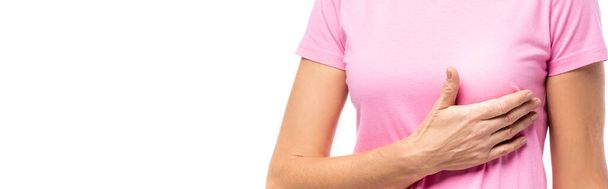 Imagen horizontal de la mujer en camiseta rosa con la mano cerca del pecho aislada en blanco - Foto, Imagen