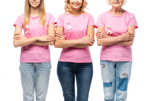 Обрезанный взгляд женщин с розовыми лентами рака молочной железы осведомленности изолированы на белом - Фото, изображение