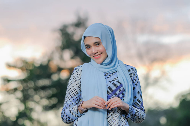 Güzel günbatımında poz veren şık tesettürlü güzel genç modelin portresi. Tarz sahibi Müslüman kadın tesettür moda tasviri. - Fotoğraf, Görsel