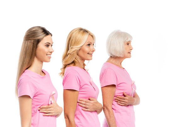Naiset vaaleanpunaisissa t-paidoissa koskettavat valkoisella eristettyjä rintoja, käsite rintasyöpä  - Valokuva, kuva